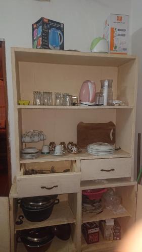 una estantería de madera con platos y platos. en Résidence la Lobe en Kribi