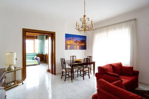 a living room with a red couch and a table at Happio Apartment in Rome