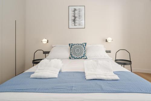 Athens City Chic Apartment-2 bathrooms في أثينا: سرير مع بطانية زرقاء ومخدات بيضاء
