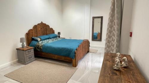 a bedroom with a bed with a wooden head board at The Old Mountain Stables Caerllwyn Ganol Farm in Newport