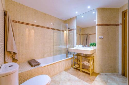 a bathroom with a tub and a sink and a toilet at Villa Humaik by Villa Plus in Antigua