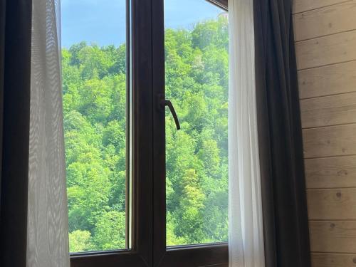 a window with a view of a forest at MaRu House in Dilijan