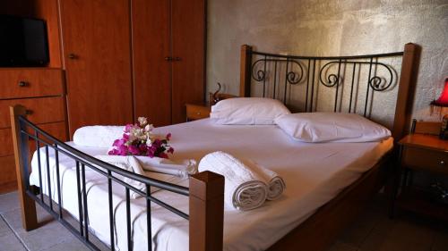 een bed met handdoeken en een boeket bloemen erop bij Remenata in Lixouri
