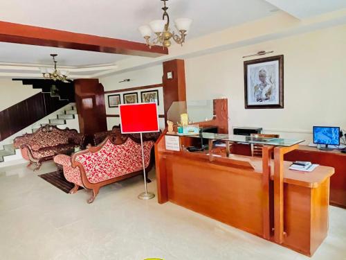 een woonkamer met een bureau en een bank bij Staynest Regency Pelling in Pelling