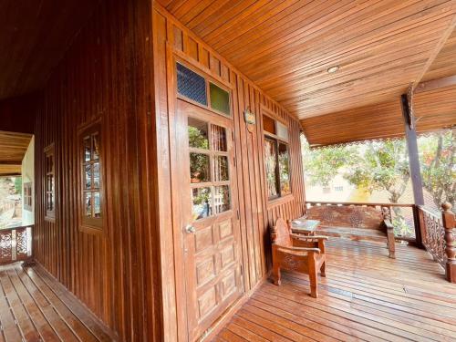 a porch of a house with a wooden door at Grand Sea Beach Resort in Haad Pleayleam