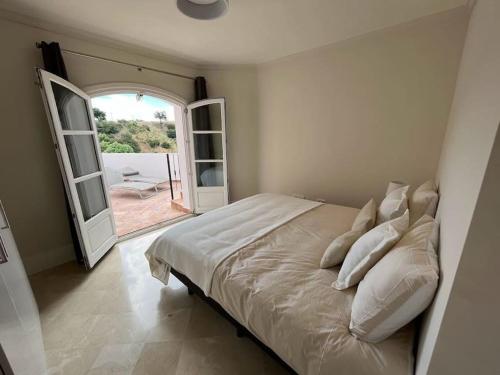 - une chambre avec un lit et une porte ouverte dans l'établissement Casa Rosado La Heredia Monte Mayor GOLF WIFI MARBELLA ESTEPONA, à Benahavís