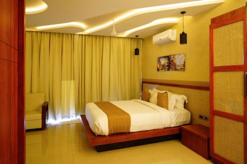 a bedroom with a large bed in a room at Mount Stratus Resort Vayalada in Bālūssheri
