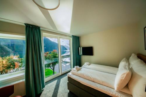 a bedroom with a bed and a large window at Klingenberg Hotel in Årdalstangen