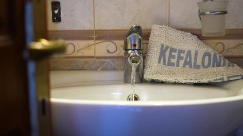 a bathroom sink with a faucet and a towel at Remenata in Lixouri