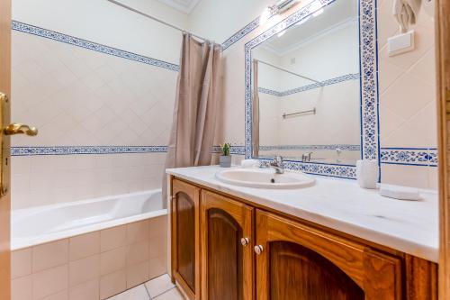 a bathroom with a sink and a tub at Quinta das Laranjeiras by Algarve Holidays in Boliqueime