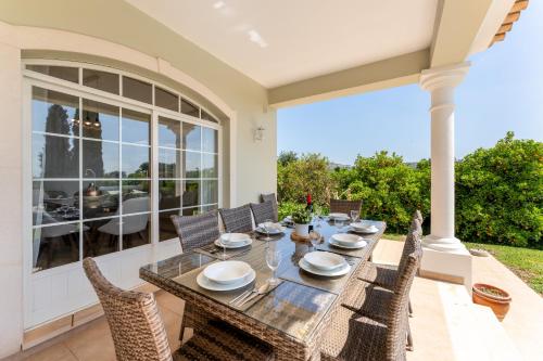 a dining room with a table and chairs on a patio at Quinta das Laranjeiras by Algarve Holidays in Boliqueime