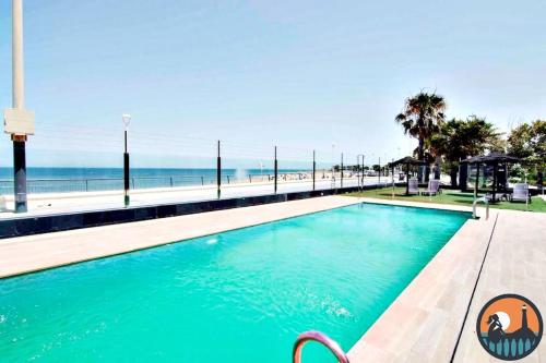 a swimming pool with the beach in the background at Cala Currican by Bossh! Apartments in Chipiona