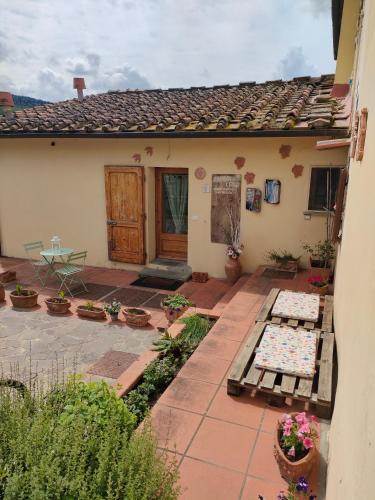 a house with a patio with a table and flowers at La petite suite in Calenzano