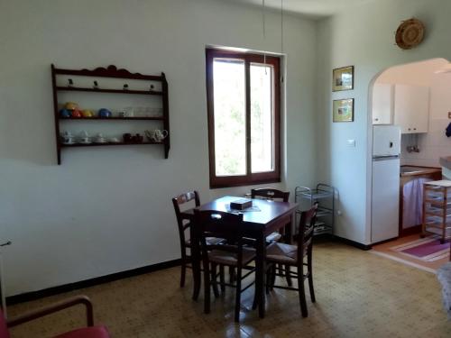 una sala da pranzo con tavolo e sedie e una cucina di Country Rooms ad Alghero