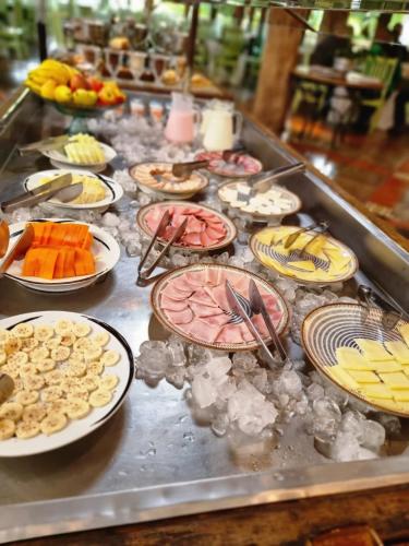 un buffet con molti piatti su un tavolo di Vila Ventura Ecoresort a Viamão
