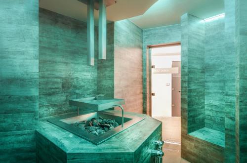 a bathroom with a fireplace in the middle at Cihelny Golf & Wellness Resort in Karlovy Vary