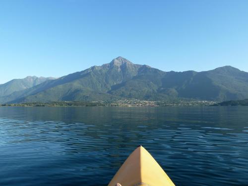 a yellow boat on the water with mountains in the background at Hotel Europa - Sorico in Sorico