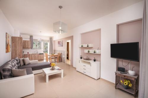 a living room with a couch and a tv at Urania Luxury Suite with pool view -Loutra Resort in Loutra