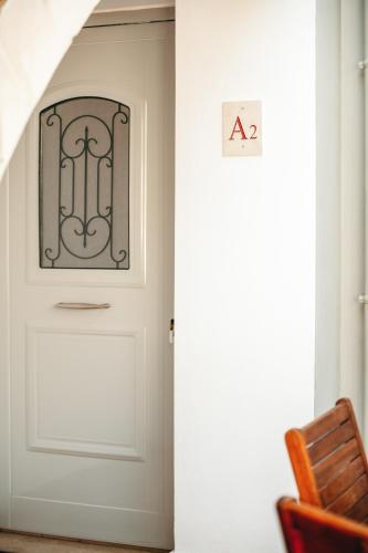 a door with a sign on it next to a chair at Urania Luxury Suite with pool view -Loutra Resort in Loutra
