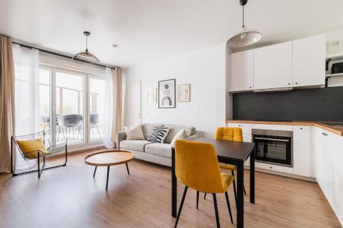 une cuisine et un salon avec une table et des chaises dans l'établissement Appartement Cosy avec terrasse aux portes de Paris, à Villejuif