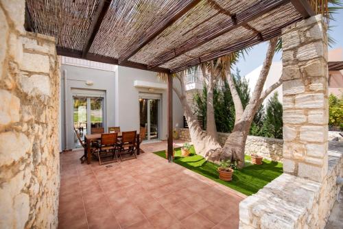 an outdoor patio with a table and chairs at Urania Luxury Suite with pool view -Loutra Resort in Loutra