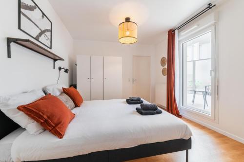 維勒瑞夫的住宿－Appartement Cosy avec terrasse aux portes de Paris，卧室配有带橙色枕头的大型白色床