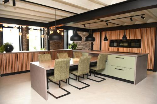 a kitchen with a dining table and chairs at Villa met 13 slaap plaatsen in Alphen