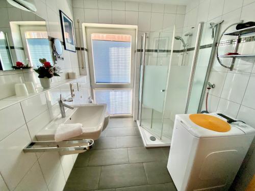 Un baño con ducha, inodoro y lavabo. en Tomke - Kolk 30, en Norddeich