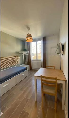 Cette chambre comprend un lit, une table et un banc. dans l'établissement La halte, à Villeurbanne