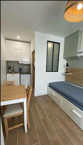 Cette chambre comprend une table, un lit et une cuisine. dans l'établissement La halte, à Villeurbanne