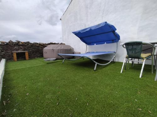 a yard with a chair and a blue object on the grass at Refúgio na Aldeia in Ourique