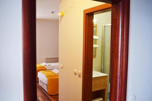 a bathroom with a mirror and a bedroom with a bed at Villa Pestani in Peštani