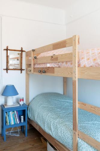 une chambre avec un lit superposé avec une table de chevet bleue dans l'établissement La Favorite - app plage à Mers, à Mers-les-Bains