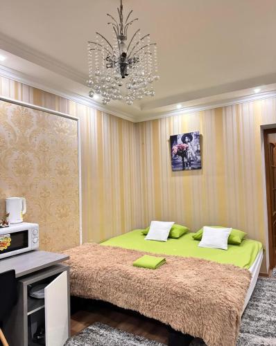 a bedroom with a large green bed with a chandelier at Comfortable apartment for you in Chişinău