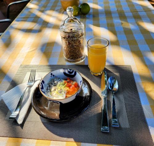 a table with a bowl of food and a glass of orange juice at Tree Aloe Guest House in Mokopane