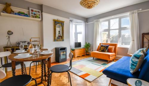 a living room with a table and a blue couch at Bowleaze Hideaway - beachside dog friendly in Weymouth