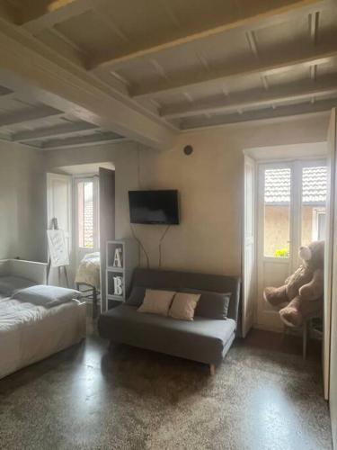 - un salon avec un canapé, un lit et des fenêtres dans l'établissement Come a casa tua, à Castelletto sopra Ticino