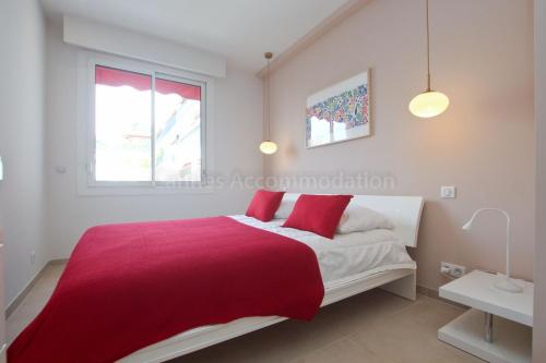 une chambre avec un lit avec une couverture rouge dans l'établissement Montrachet, à Cannes