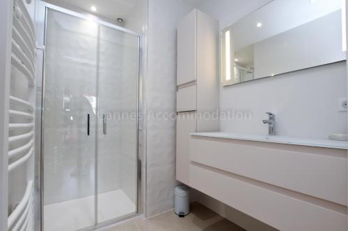 une salle de bain blanche avec une douche et un lavabo dans l'établissement Montrachet, à Cannes