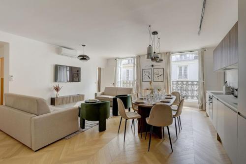 une cuisine et un salon avec une table et des chaises dans l'établissement Sublime Apartment Champs Elysées 8Guests 3Bdr, à Paris