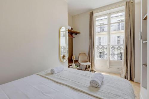 une chambre blanche avec un lit et une fenêtre dans l'établissement Sublime Apartment Champs Elysées 8Guests 3Bdr, à Paris