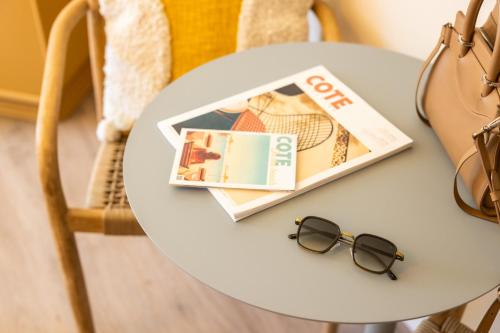 a table with a magazine and glasses on it at Nice Pam Hotel Fully Renovated in Nice