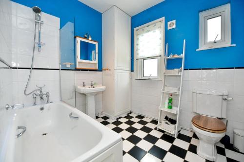 uma casa de banho com uma banheira, um WC e um lavatório. em Beautiful family home in Mumbles, with garden em The Mumbles