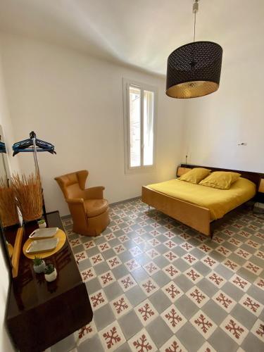 une chambre avec un lit et une chaise dans l'établissement Grand appartement en centre ville avec terrasse, à Perpignan