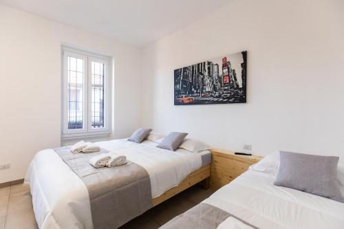 um quarto com duas camas e um quadro na parede em CityHouse Fm StationRho Fair Near center em Rho