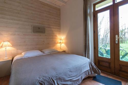 a bedroom with a bed and a window and a door at La Ferme Montplaisir in Montesquieu-Volvestre