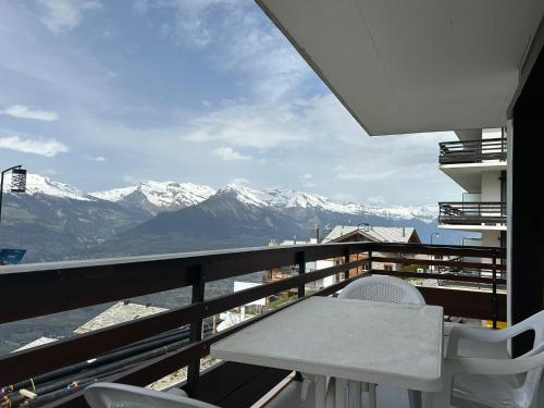 a balcony with a table and a view of mountains at Diablerets SKI LIFT & MOUNTAIN apartments in Veysonnaz