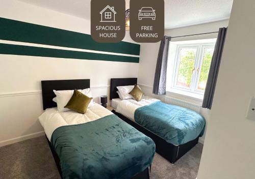 two beds in a room with a free parking sign at M62 - Contractor Stays - Families - Relocation in Huyton with Roby