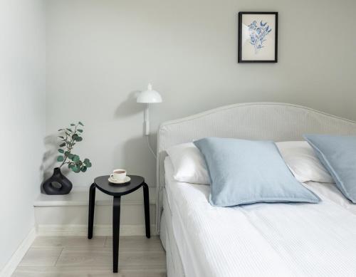 a white bed with a side table in a bedroom at St Florian Apartments in Kraków