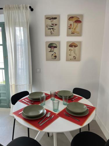 uma mesa branca com quatro cadeiras e pratos em The sunnydise Apartment LUXURY DUPLEX in the city center em Málaga